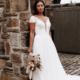 Bohemian style wedding dress in ivory with plunge neckline and delicate lace detail.