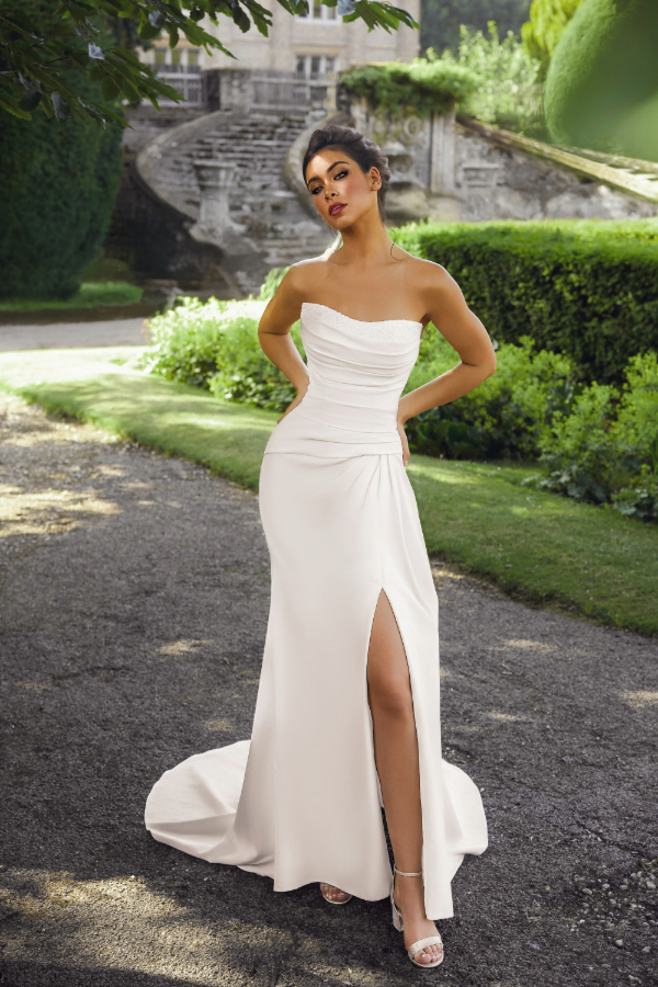 Fit and flare wedding dress in ivory. Strapless with beaded neckline and front split