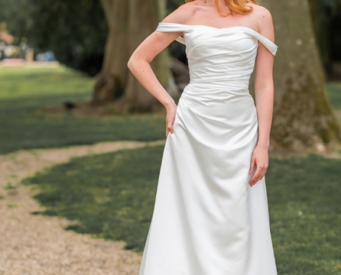 Ivory satin wedding dress with drop shoulder sleeves. A line style with button and lace back detailing.