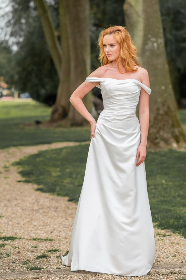 Ivory satin wedding dress with drop shoulder sleeves. A line style with button and lace back detailing.