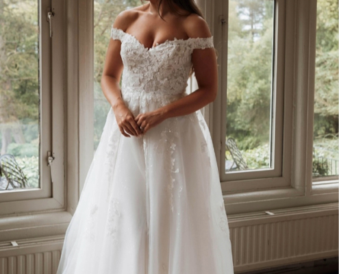 Off the shoulder wedding dress with floral lace applique and sparkling layers
