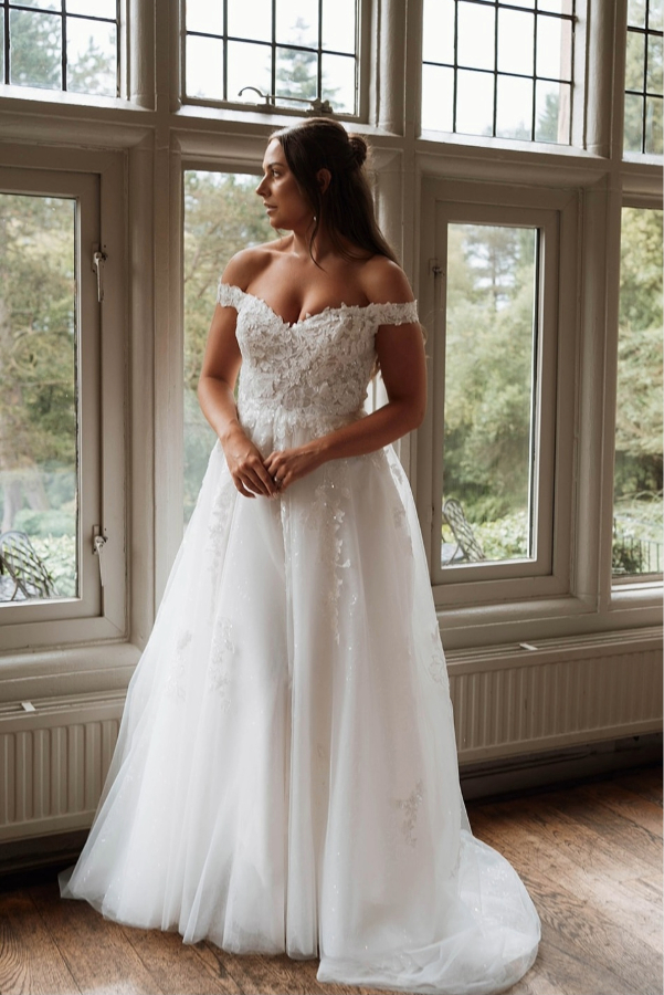 Off the shoulder wedding dress with floral lace applique and sparkling layers